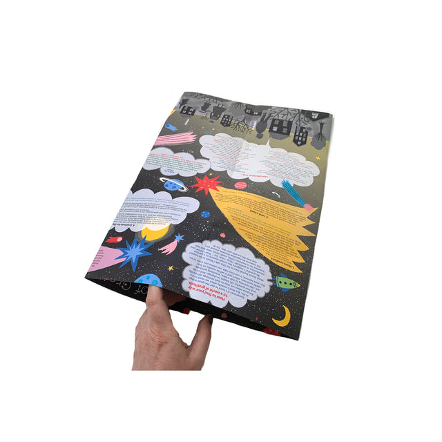 Photo showing a hand holding the folded Mapology Guide “What’s With This Gratitude Thing?” revealing its colourful interior filled with stars, planets, and gratitude prompts.