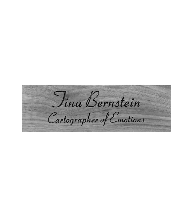 a wooden desk sign with the name of Tina Bernstein adn Cartographer of Emotions engraved