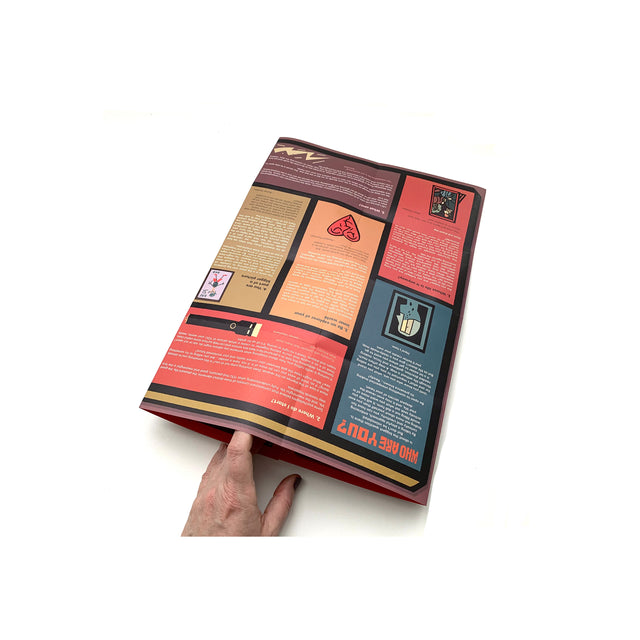 Photo showing a hand holding open the folded Mapology Guide “Who Are You?”, revealing sections of illustrated prompts and reflections about identity, purpose, and personal growth.